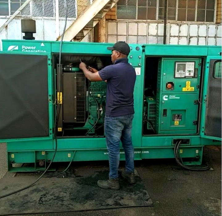 PowerFix engineer carrying out on-site diesel generator repair on a Cummins-powered set in Lagos